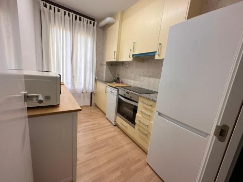 a kitchen with white appliances and a white refrigerator at Ruta del ferro in Ripoll