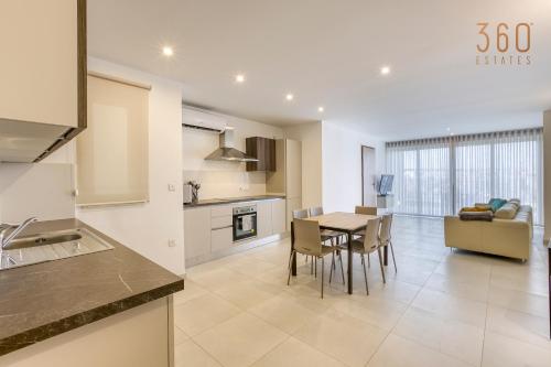 a kitchen and dining room with a table and chairs at Wonderful marina 3BR home, with LUX interior w/AC by 360 Estates in Tal-Pietà
