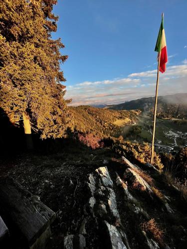 a flag on top of a hill with a view at Hotel Rech-Hof Sayonara in Folgaria