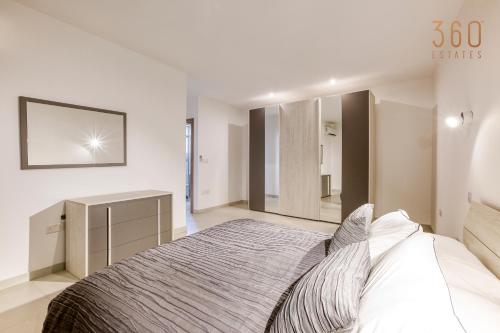a bedroom with a large bed and a mirror at Wonderful marina 3BR home, with LUX interior w/AC by 360 Estates in Tal-Pietà
