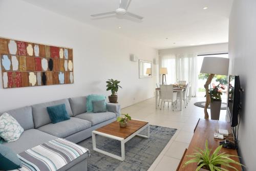 a living room with a couch and a table at Cap Ouest Beachfront Luxury Penthouse & Apartment in Flic-en-Flac
