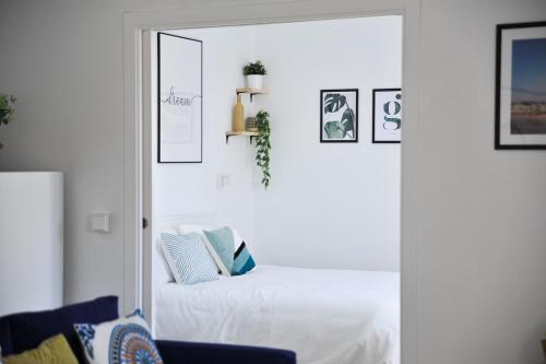 a white room with a bed and a mirror at El Apartamento de Nueva in Cádiz