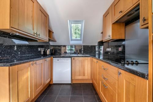 a kitchen with wooden cabinets and a white dishwasher at The Kenmore Club in Kenmore