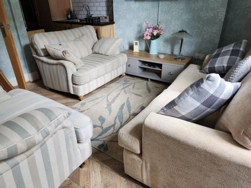 a living room with two chairs and a couch at Largs holiday flat in Largs