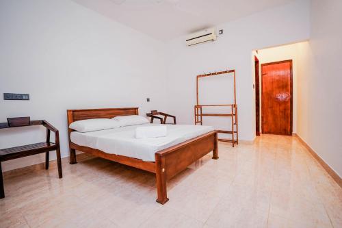 a bedroom with a bed and a chair and a door at River Inn in Matara