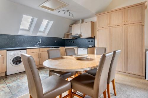 a kitchen with a wooden table and chairs at The Kenmore Club in Kenmore