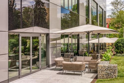 a patio with chairs and umbrellas in front of a building at Geneva Marriott Hotel in Geneva