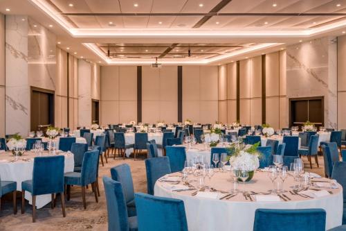 a ballroom with tables and chairs with blue chairs at Geneva Marriott Hotel in Geneva