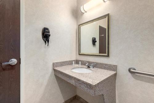 y baño con lavabo y espejo. en Baymont by Wyndham Pratt, en Pratt