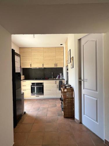 eine Küche mit einer Tür, die sich zu einer Küche mit einer Theke öffnet in der Unterkunft Cabanon provençal in Rochefort-du-Gard