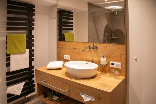a bathroom with a sink and a mirror at Landhotel Halbfas-Alterauge in Drolshagen