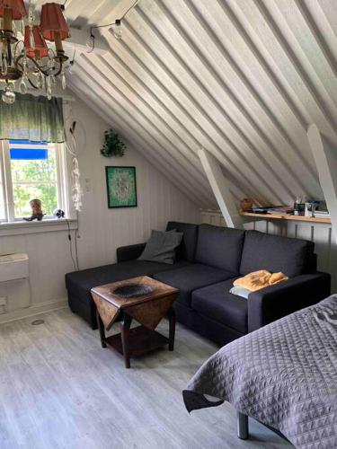 uma sala de estar com um sofá e uma mesa em Mysigt boende på landet nära naturen em Ödeshög