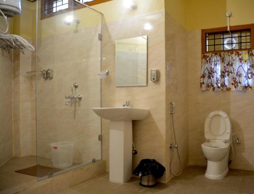 y baño con lavabo, ducha y aseo. en Nirvana Guest House, en Guwahati