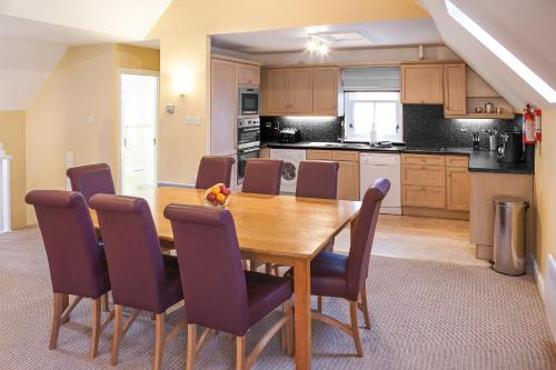 a kitchen with a wooden dining room table and chairs at The Kenmore Club in Kenmore