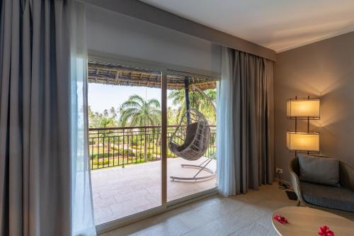 a living room with a large glass door leading to a patio at TUI BLUE Bahari Zanzibar in Pwani Mchangani