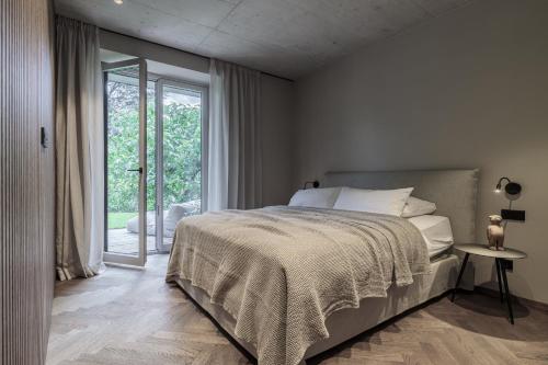 - une chambre avec un lit et une grande fenêtre dans l'établissement Meran Suites Nice Five One, à Merano