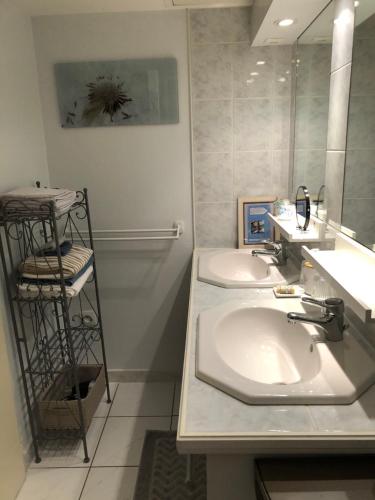 a bathroom with two sinks and a mirror at La Boisnière in Mouilleron-en-Pareds