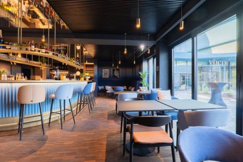 a restaurant with tables and chairs and a bar at voco Brussels City North by IHG in Vilvoorde