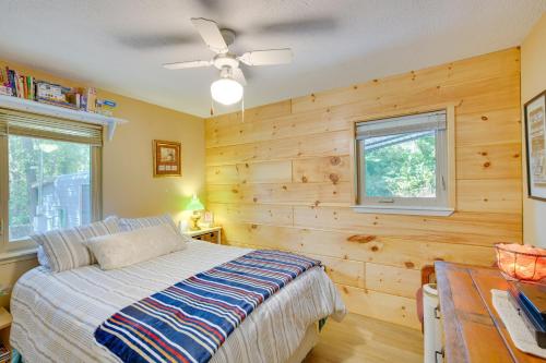 ein Schlafzimmer mit einem Bett und einer Holzwand in der Unterkunft Kilgore Lakefront Home with Private Dock and Pier! in Kilgore