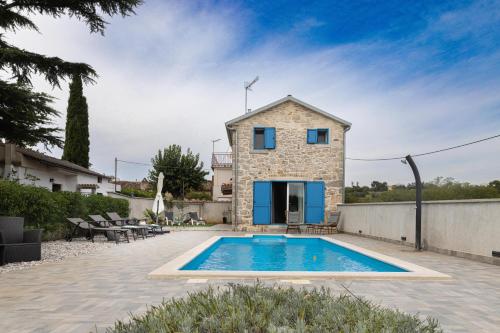 a villa with a pool in front of a house at Villa Allegra in Vižinada