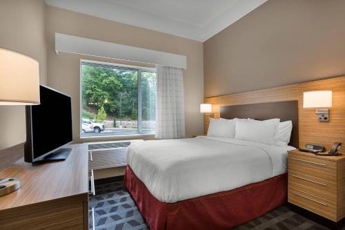 a hotel room with a bed and a television at TownePlace Suites Boone in Boone