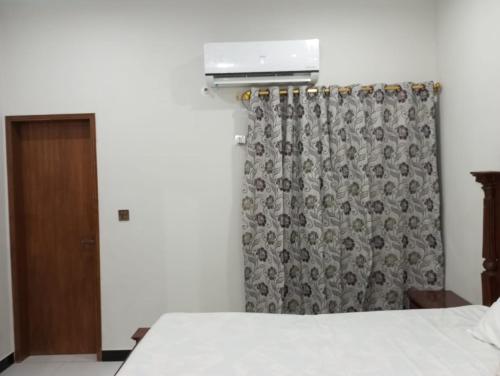 a bedroom with a bed and a curtain at Nursery Inn in Karachi