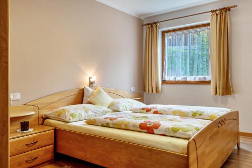 1 dormitorio con 2 camas y ventana en Obertegghof Wohnung Schartenblick, en Sarentino