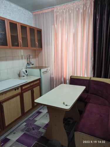 a small kitchen with a table and a couch at Restful sleep apartments in Karakol