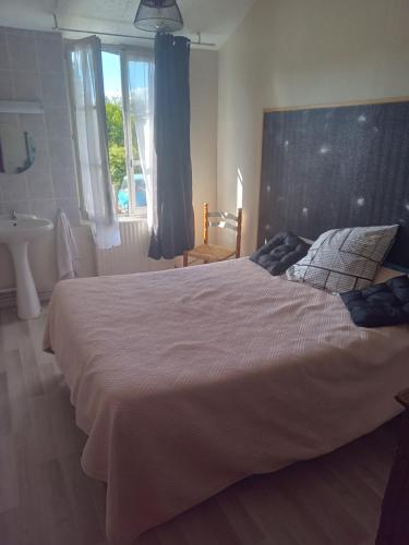 sypialnia z dużym łóżkiem i umywalką w obiekcie aurelie w mieście Saint-Pierre-le-Moûtier
