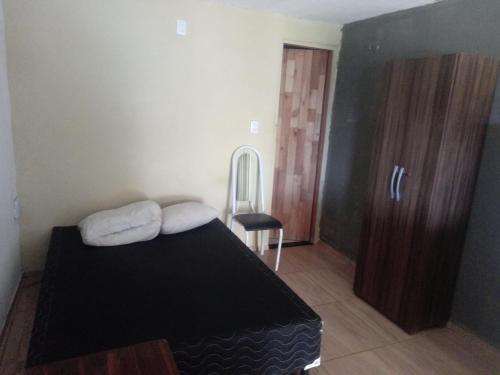 a small bedroom with a bed and a chair at Zion Land Canoa Quebrada in Aracati