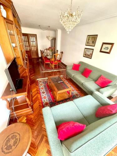 uma sala de estar com um sofá azul e almofadas vermelhas em El piso de Sabina em Santander