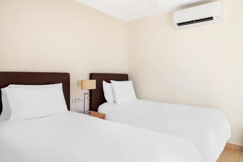 アデへにあるサンセット ハーバー クラブ バイ ダイヤモンド リゾーツのベッド2台が隣同士に設置された部屋です。