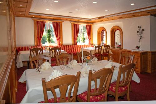 a dining room with tables and chairs with white tablecloths at Landhotel Halbfas-Alterauge in Drolshagen