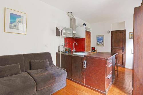un salon avec un canapé et une cuisine dans l'établissement Studio Empresa - Welkeys, à Paris
