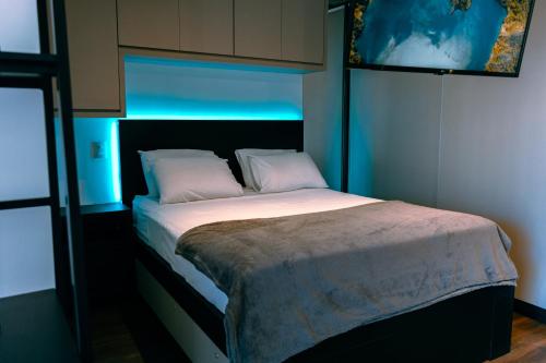 um quarto com uma cama num quarto azul em Studio a 100m Bosque, Centro e Cambuí- Home Office, Piscina, Sauna, Jacuzzi, Fitness em Campinas
