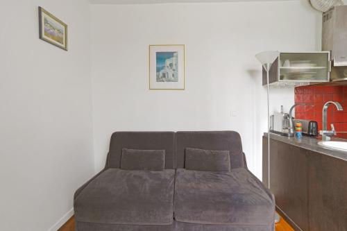 - un canapé avec deux oreillers dans l'établissement Studio Empresa - Welkeys, à Paris