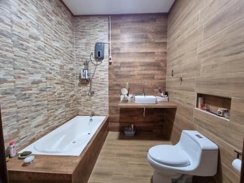 La salle de bains est pourvue d'une baignoire, de toilettes et d'un lavabo. dans l'établissement Martina House, à Iquitos