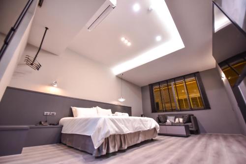 - une chambre avec un grand lit et une fenêtre dans l'établissement Two Couples Leisure Art Motel, à Tainan
