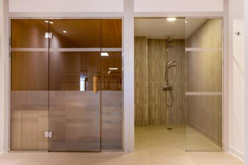Una ducha de cristal en una habitación con puerta de cristal en Royal Oasis Club at Pueblo Quinta en Benalmádena