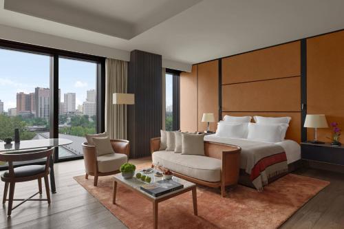 a hotel room with a bed and a large window at Bulgari Hotel, Beijing in Beijing