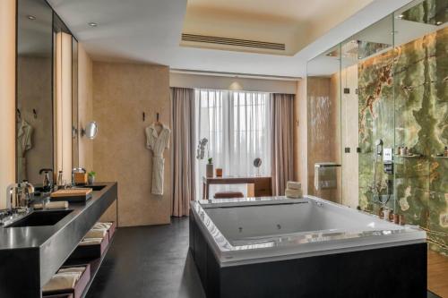 a bathroom with a large tub and a sink at Bulgari Hotel, Beijing in Beijing