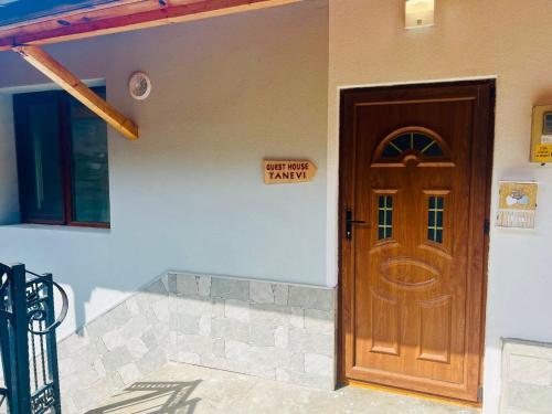 a house with a wooden door with a sign on it at Guest House Tanevi in Devin
