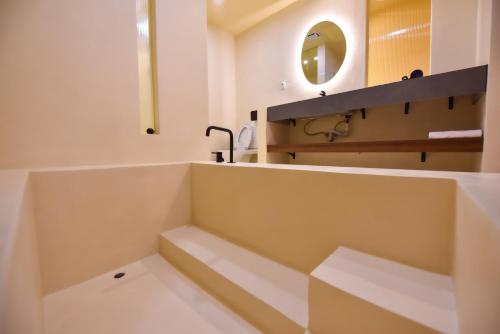 a white bathroom with a sink and a mirror at Two Couples Leisure Art Motel in Tainan