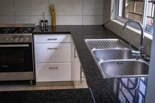 a kitchen with a sink and a stove at Riverside Residence - BEAU VALLON in Beau Vallon