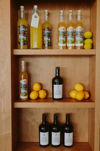 a shelf with bottles of alcohol and lemons on it at Hotel Limone in Limone sul Garda