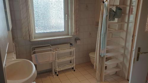 a bathroom with a sink and a toilet and a window at Ferienhaus mit großem Garten in Bad Gandersheim