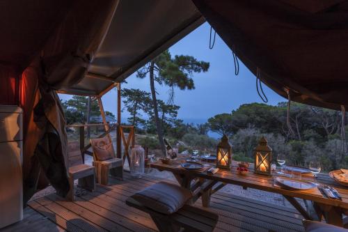 a wooden deck with a table in a tent at Fattoria delle Ripalte in Capoliveri