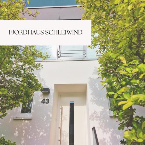 a white building with the words hürkus schlemmer at Fjordhaus Schleiwind in Fahrdorf