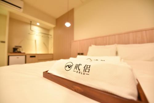 a bed with a white blanket on top of it at Two Couples Leisure Art Motel in Tainan
