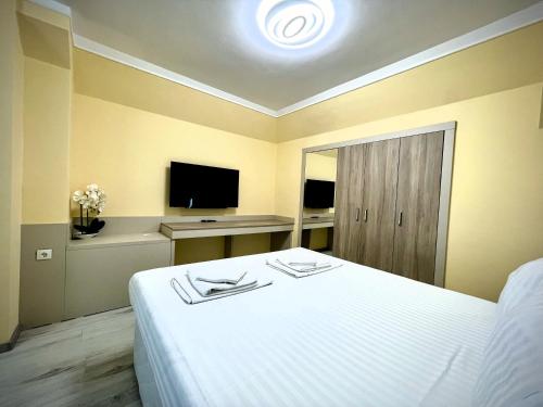 a hotel room with a bed and a television at Private apartments Stamopolu lux in Primorsko